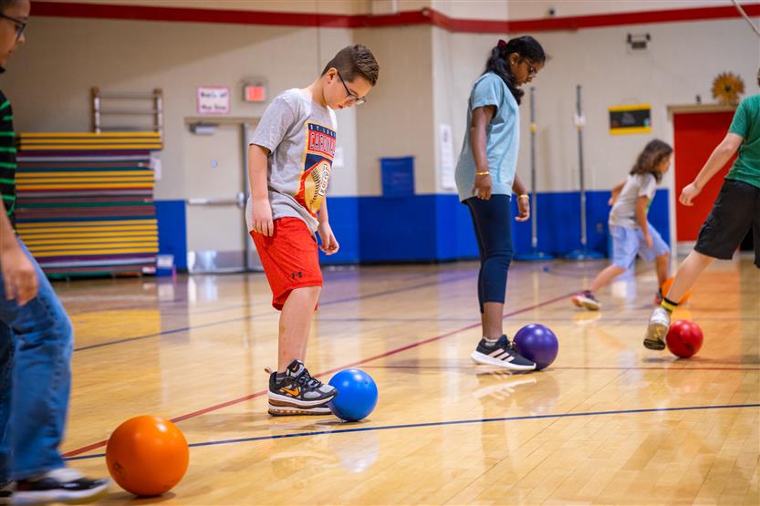 Students prepare to dribble the soccer ball